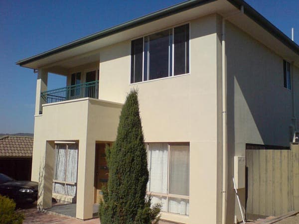Two-storey extension with a wraparound upstairs balcony, tiled roof and off-street parking